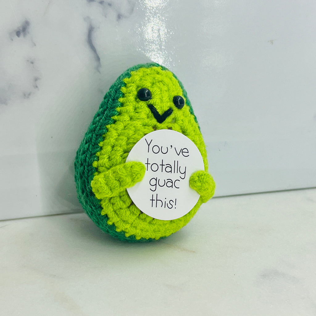Crocheted avocado plush toy with a humorous message 
